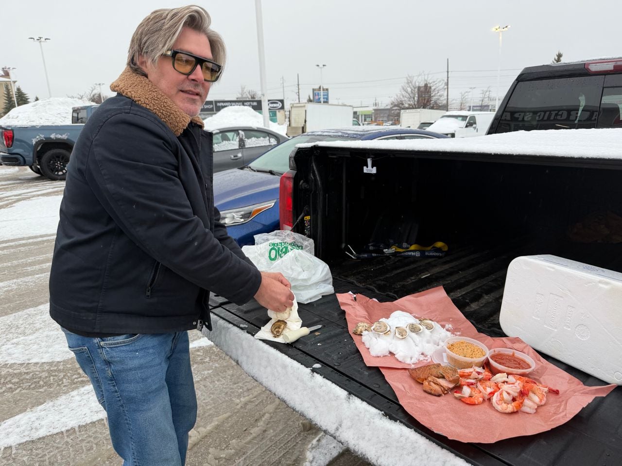 Randy Feltis shucks oysters on the back of a pickup truck
