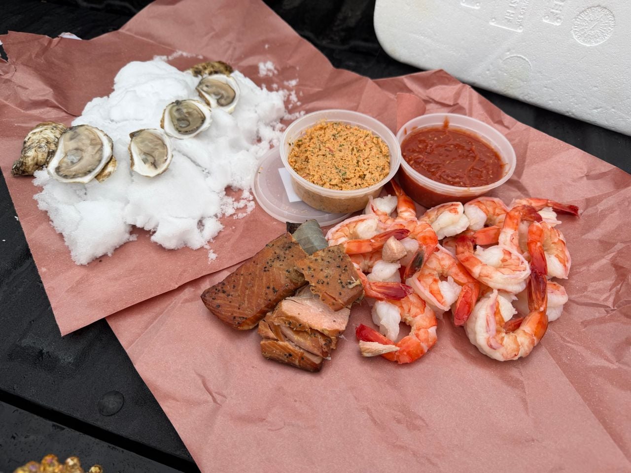 A spread of shucked oysters, smoked salmon, shrimp and sauces