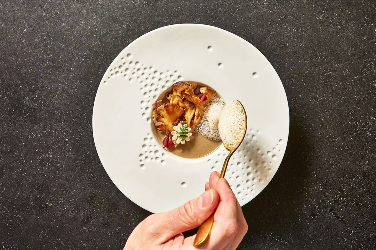 A chef plates a dish at Onze