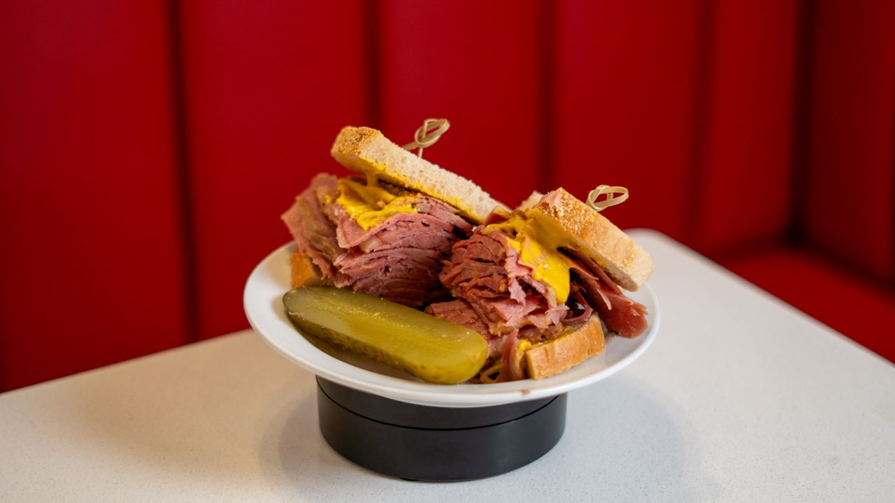 A smoked meat sandwich with a pickle