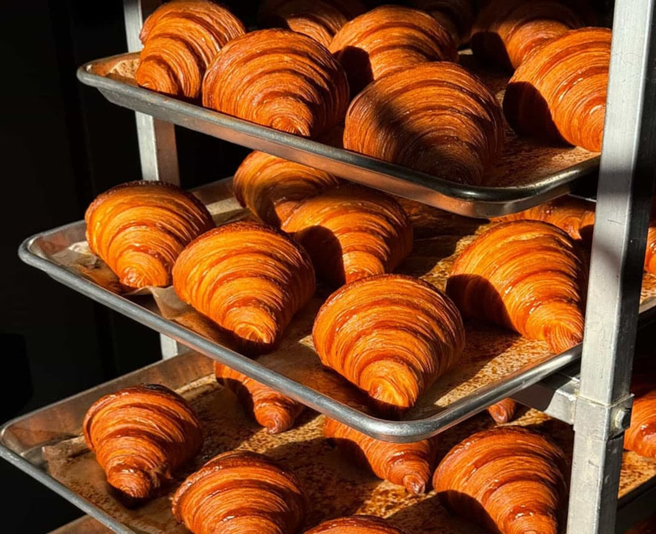 A closeup of croissants on baking trays