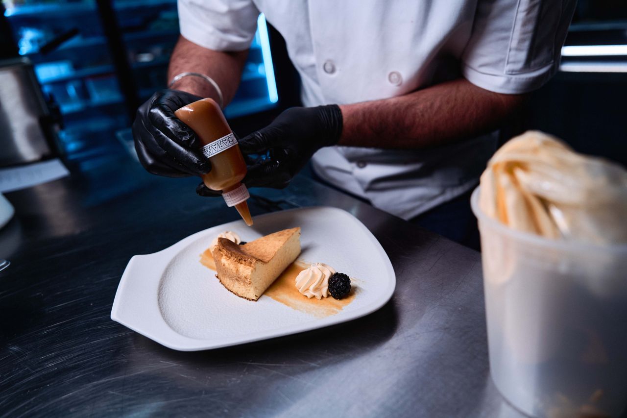 A chef finishes a dessert in the kitchen of Aangan