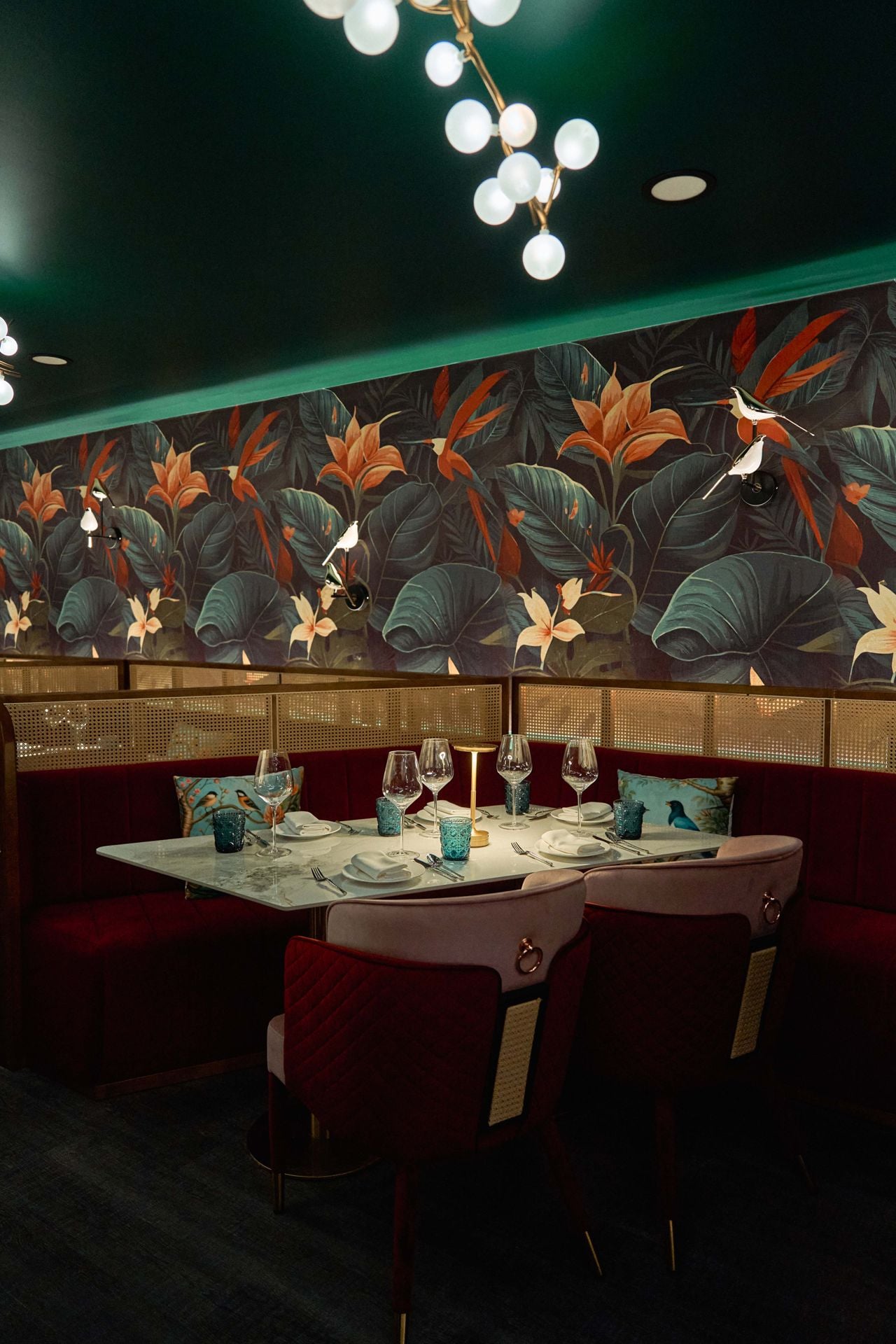 Jungle-inspired wallpaper lines the walls in the dining room at Aangan