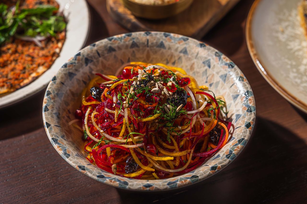 This tumble of spiralized golden and red beets is dressed in a grape molasses vinaigrette spiked with pomegranate seeds and dried cherries