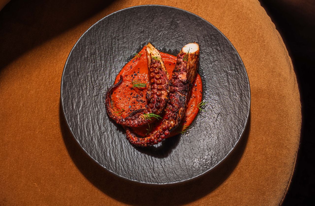 Two fat octopus tentacles on a sweet and smoky purée of roasted peppers and semi-dried cherry tomatoes