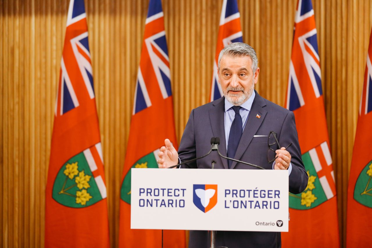 Education minister Paul Calandra speaking at a podium