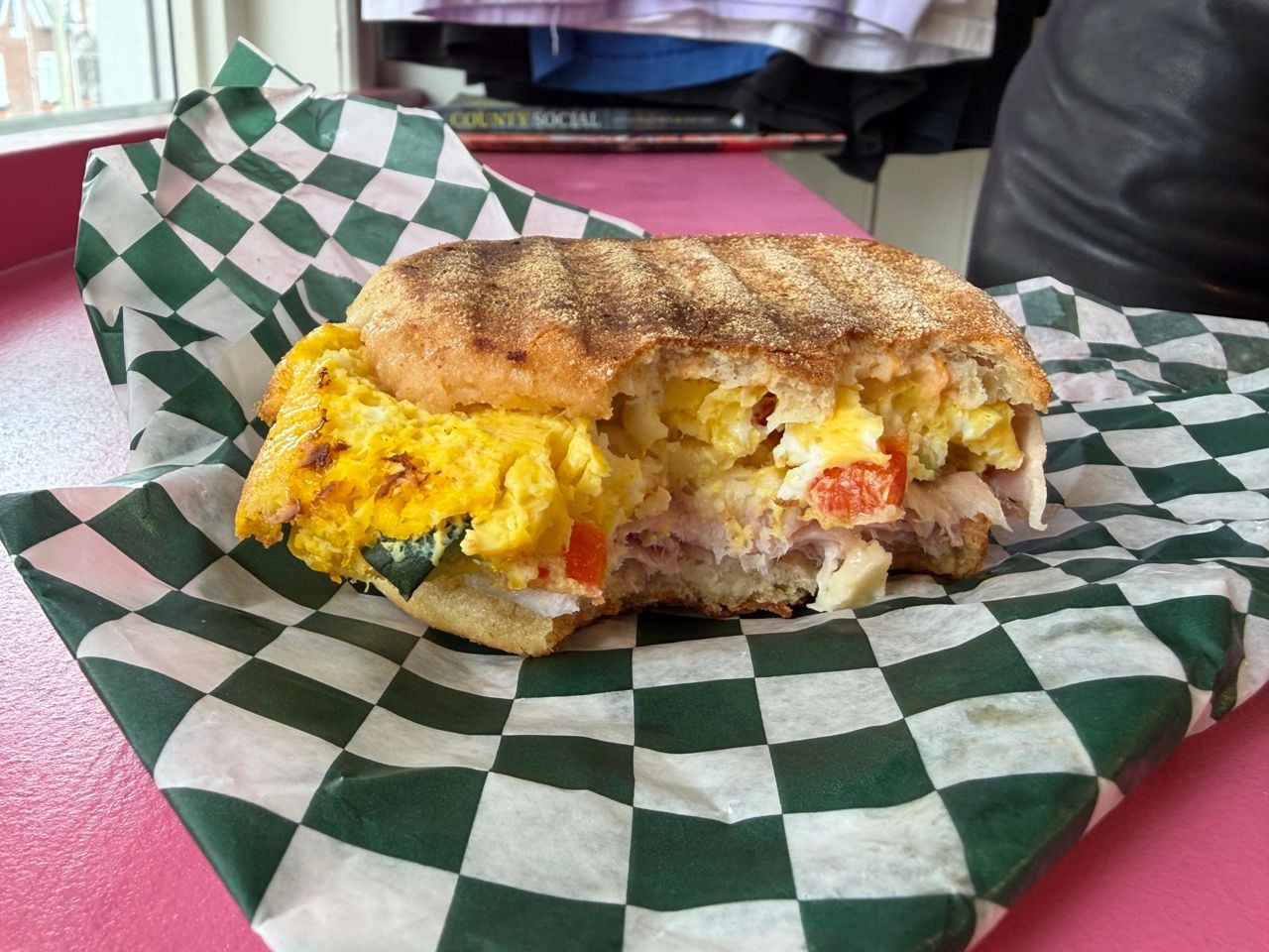 A closeup of a breakfast sandwich with a bite out of it