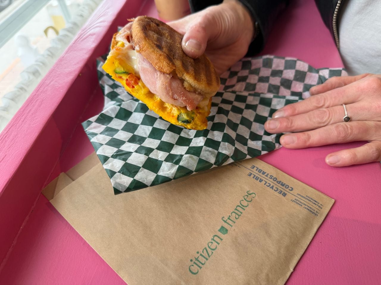 A person holds a breakfast sandwich