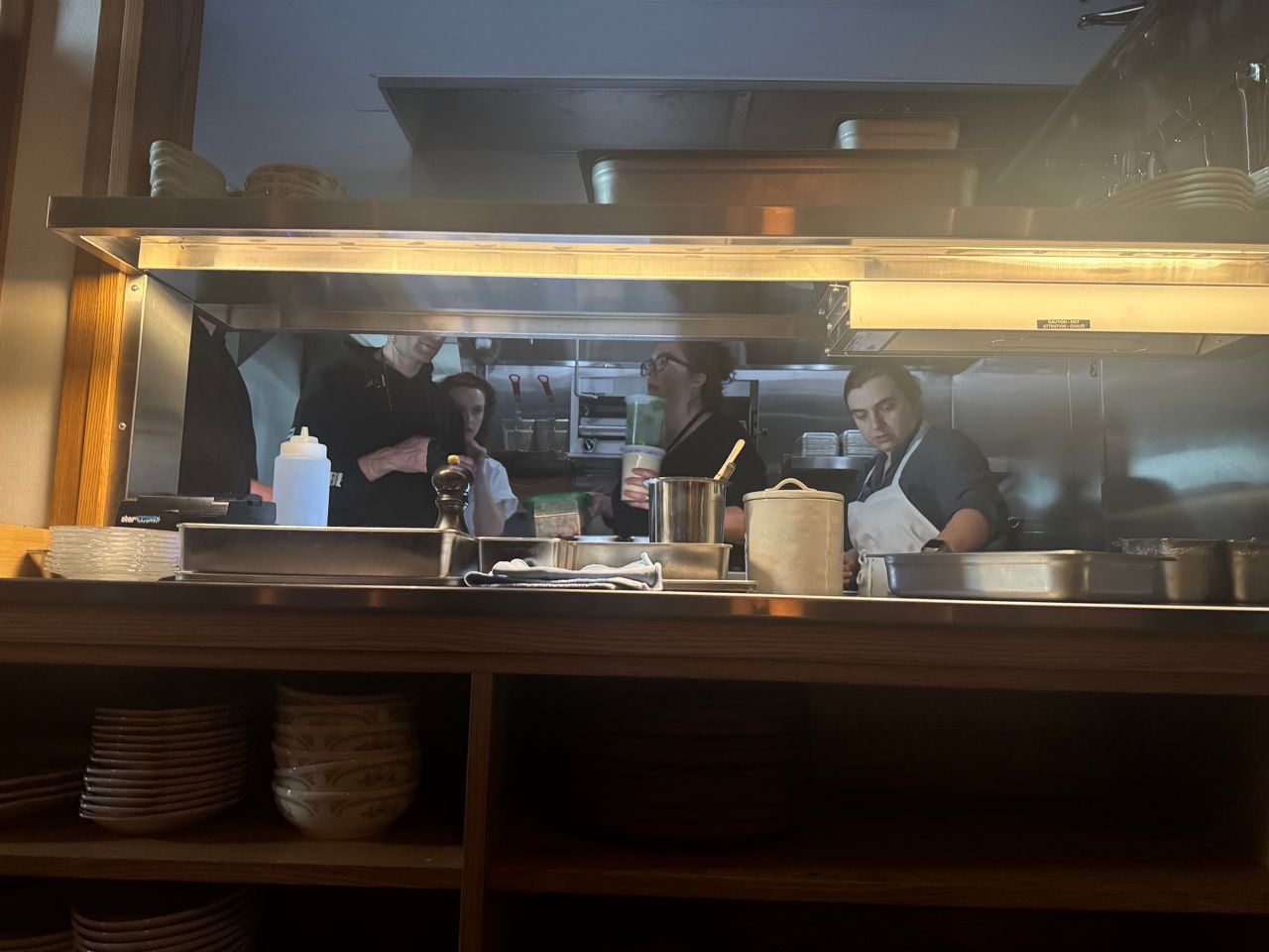 A team of chefs and actors works in a kitchen during a film shoot