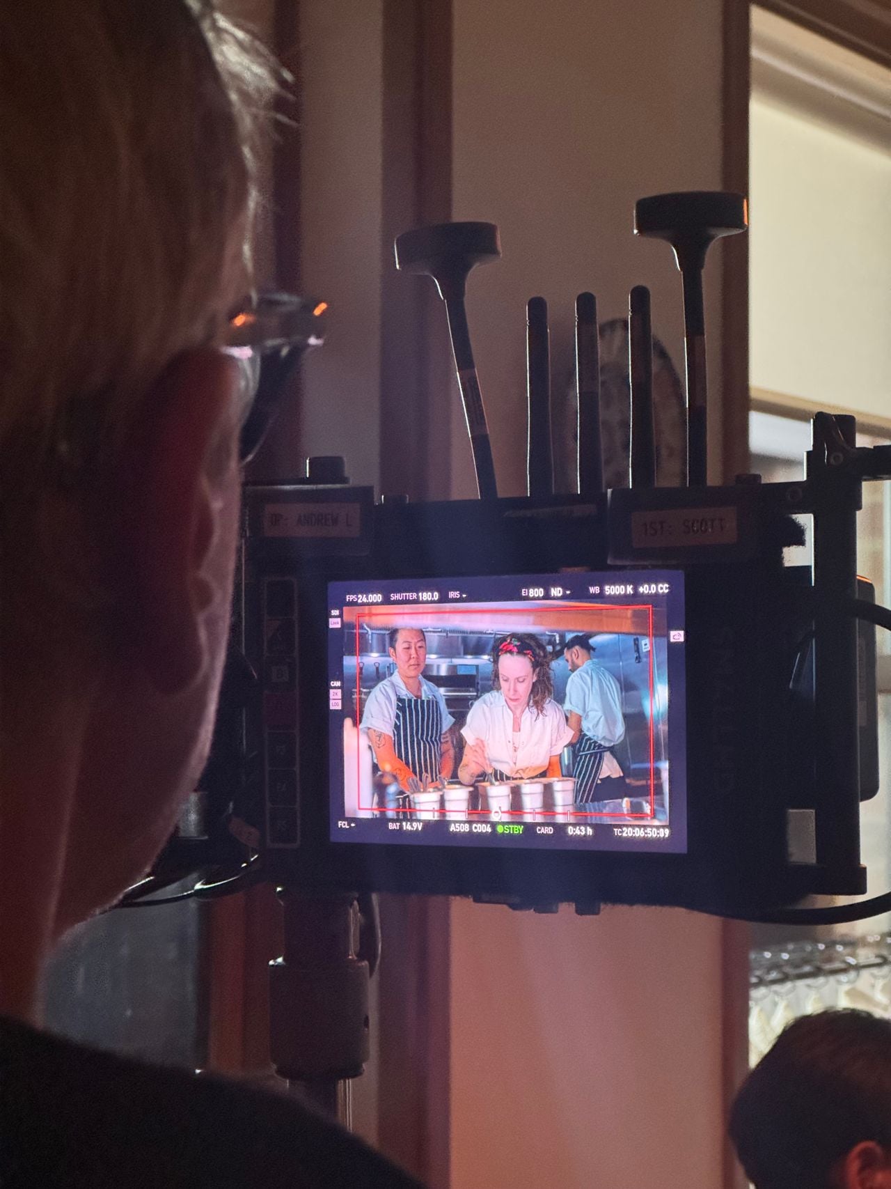 A director watches a live scene take place on a screen while filming