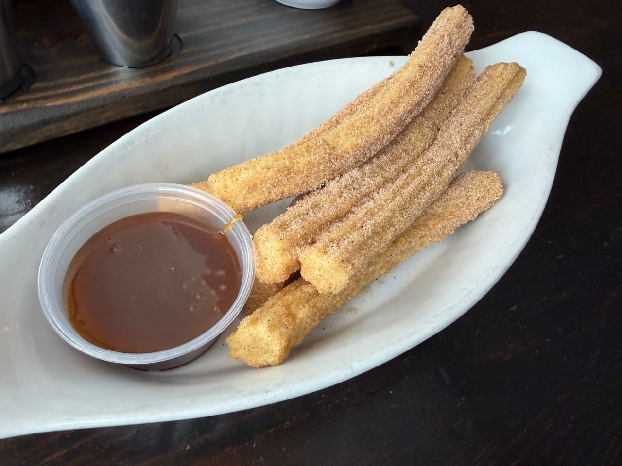 A plate of churros with caramel sauce