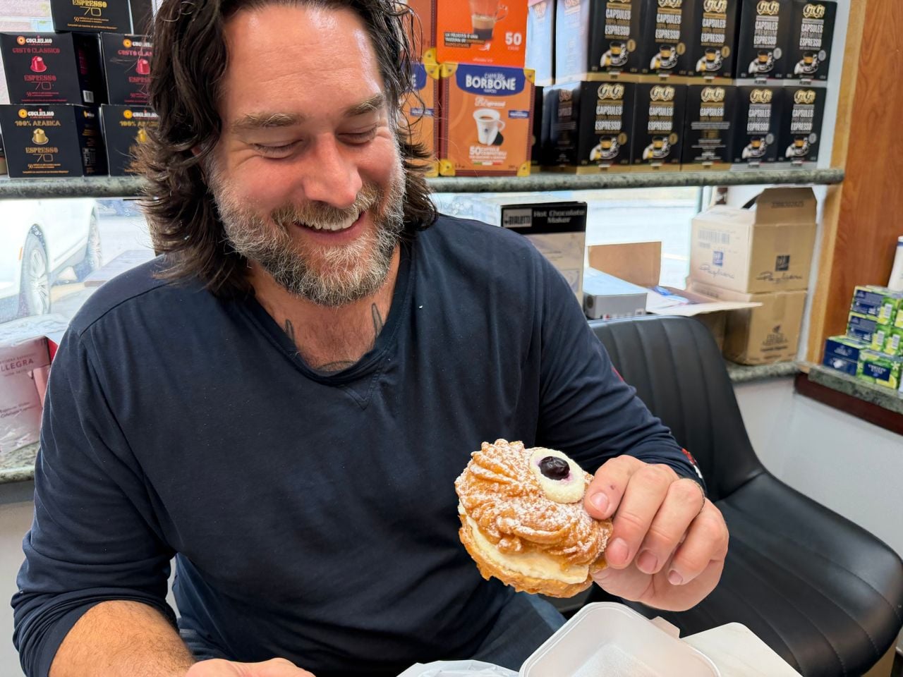 Chef Michael Hunter laughs while holding a zeppole