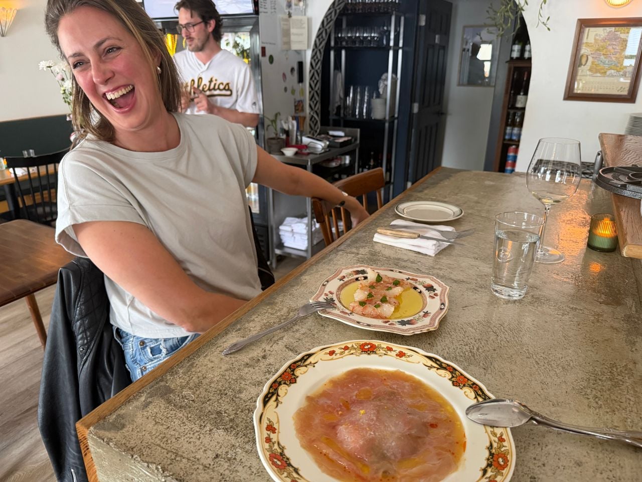 Chef Amanda Ray sits at the bar counter at Theia and laughs