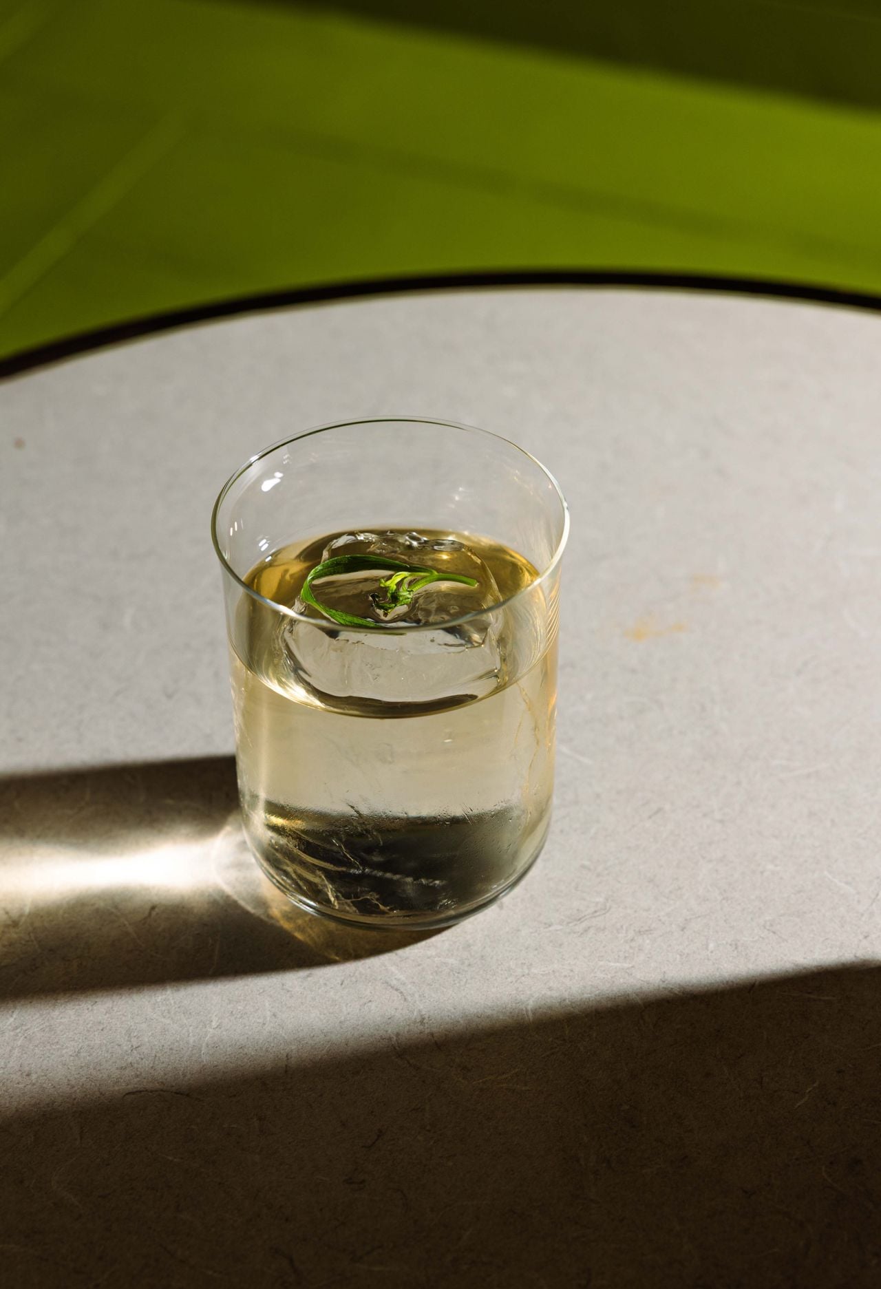 A clear cocktail in a lowball