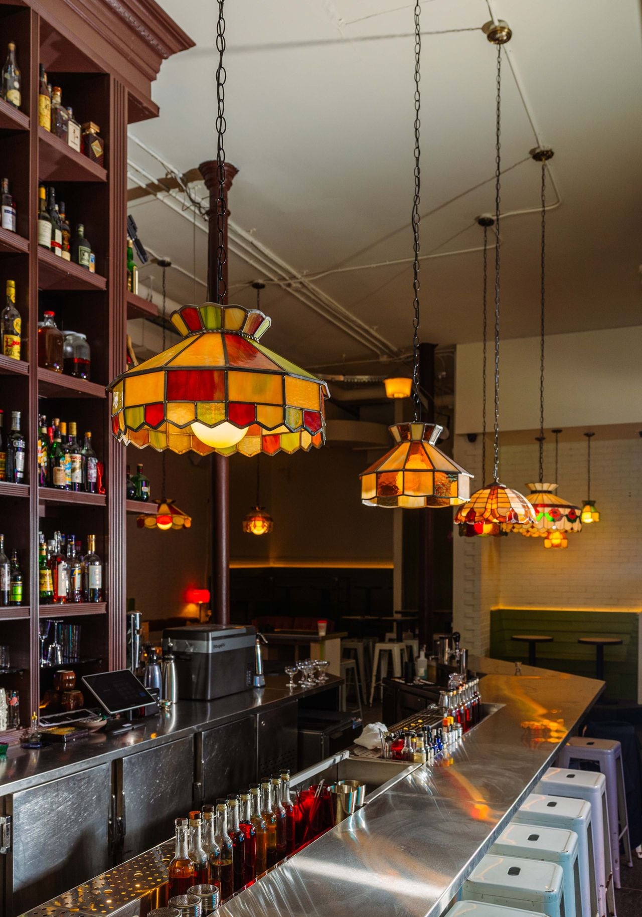 The bar at Dirty Laundry, with stained-glass light fixtures overhead