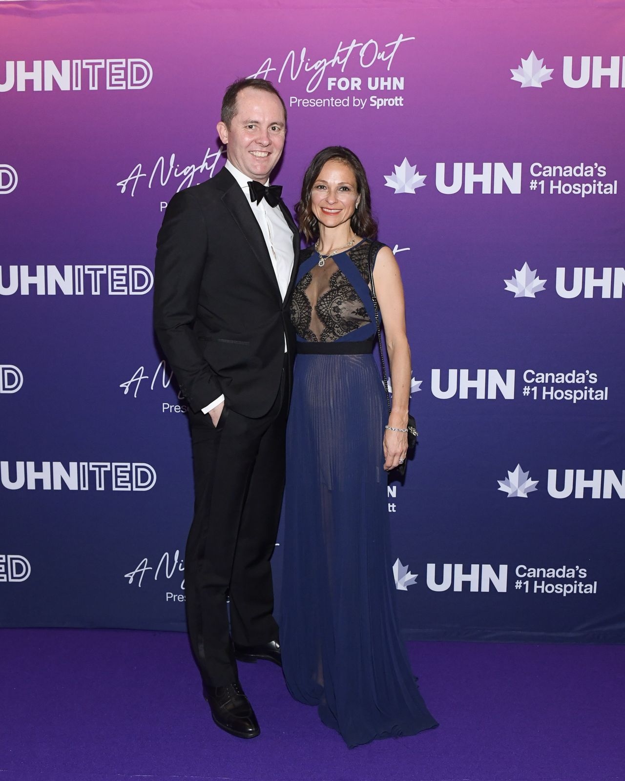 Man in suit and woman in navy lace dress