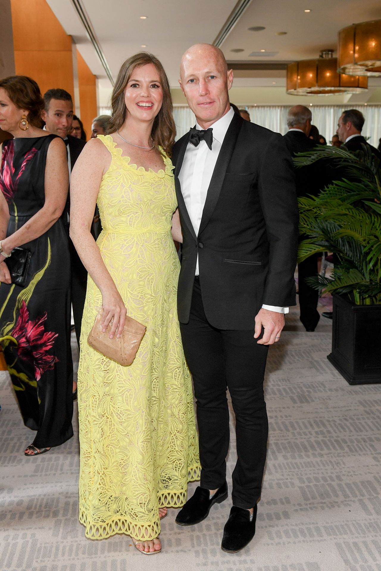 Woman in a yellow dress next to a bald guy
