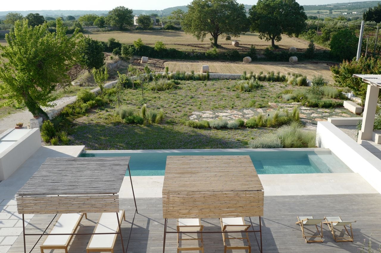 A patio and pool looking over a garden and countryside