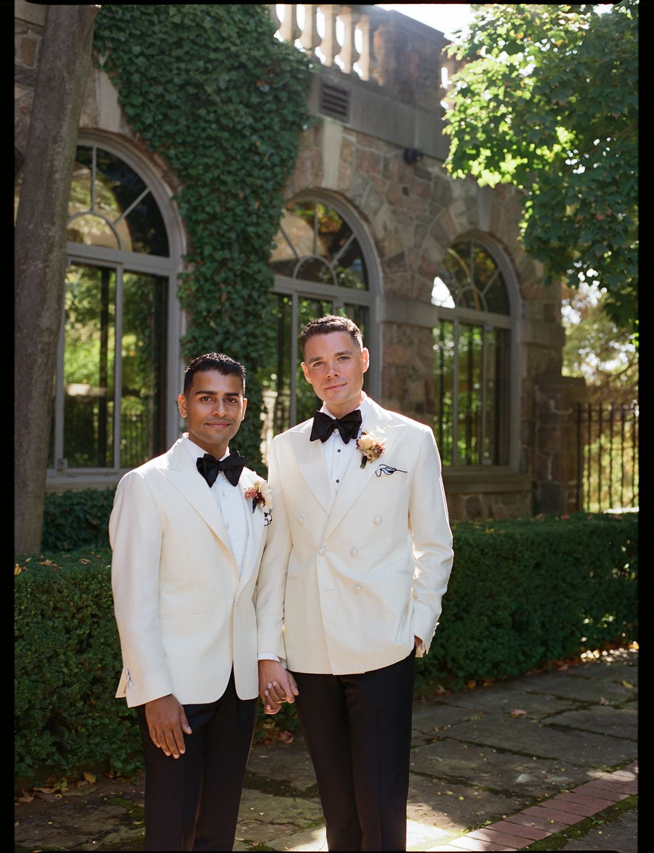 Two grooms in white jackets embracing