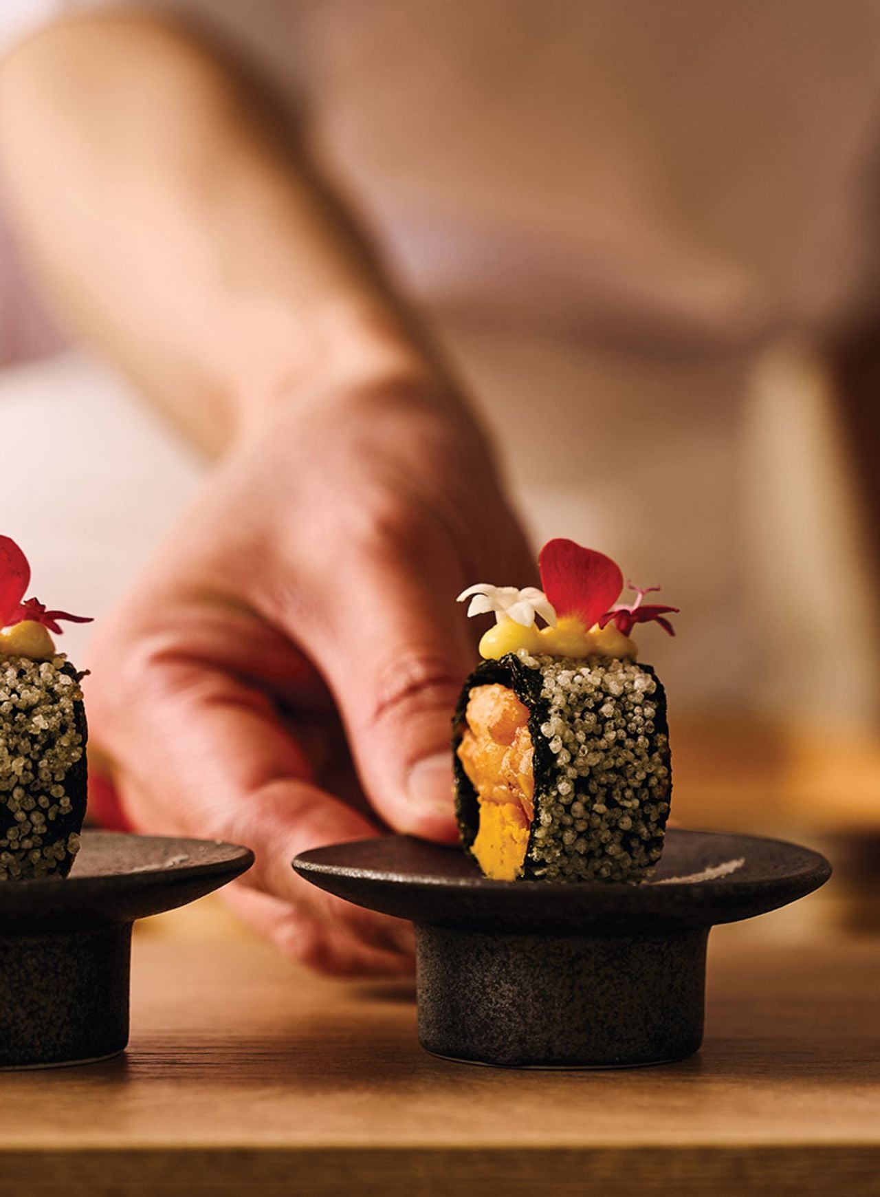 A chef from the Onda presents a tiny plate with a single piece of lobster maki