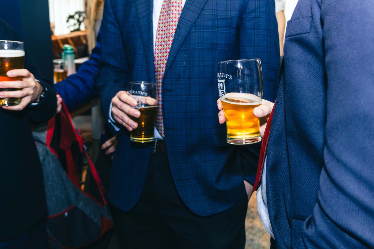 People hold pints of beer at the House of McGrath