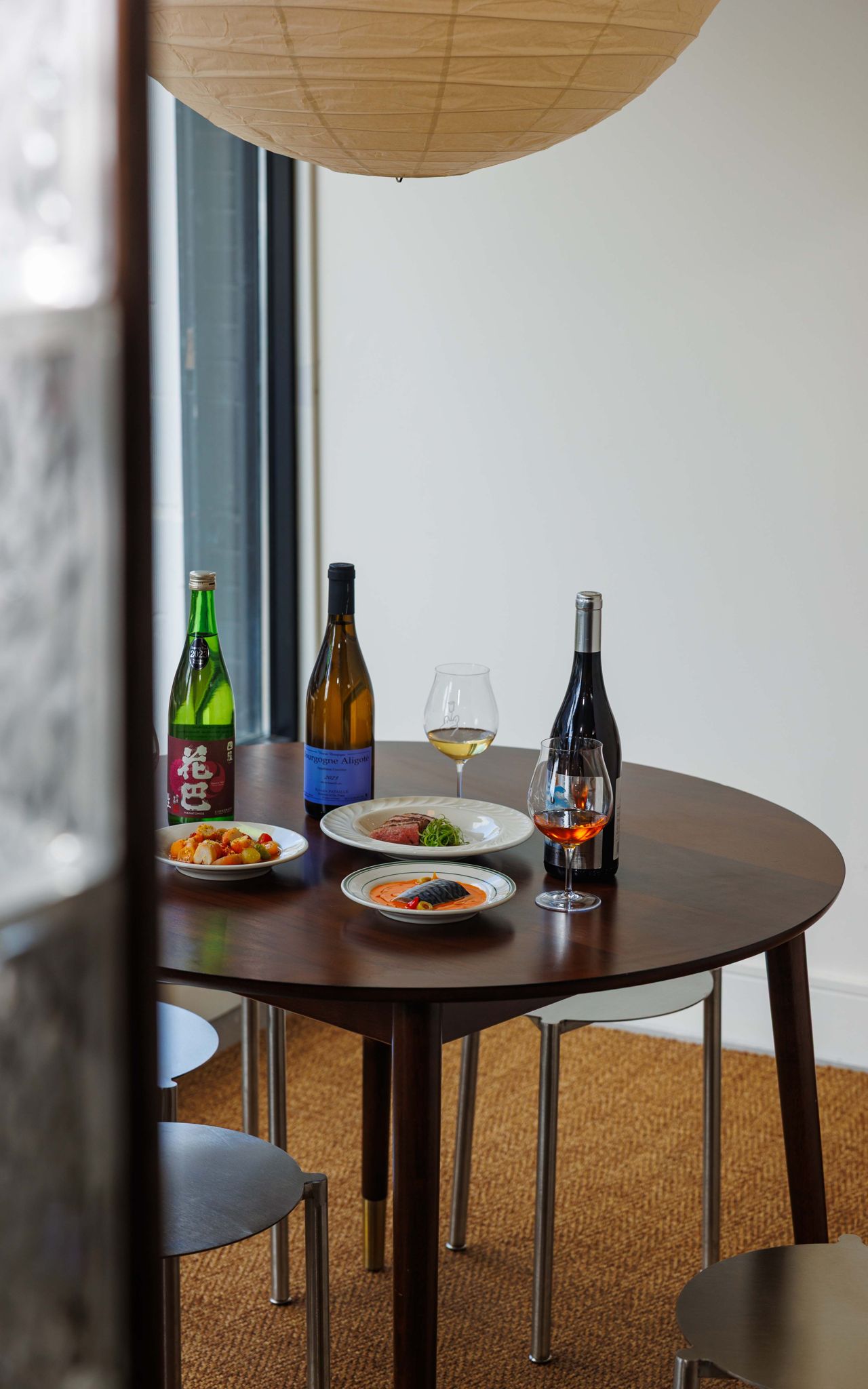 A table at Chez Wa set with dishes and bottles of wine and sake