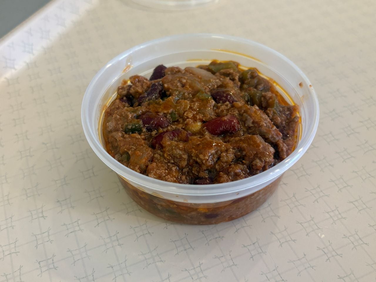 A plastic container of chili