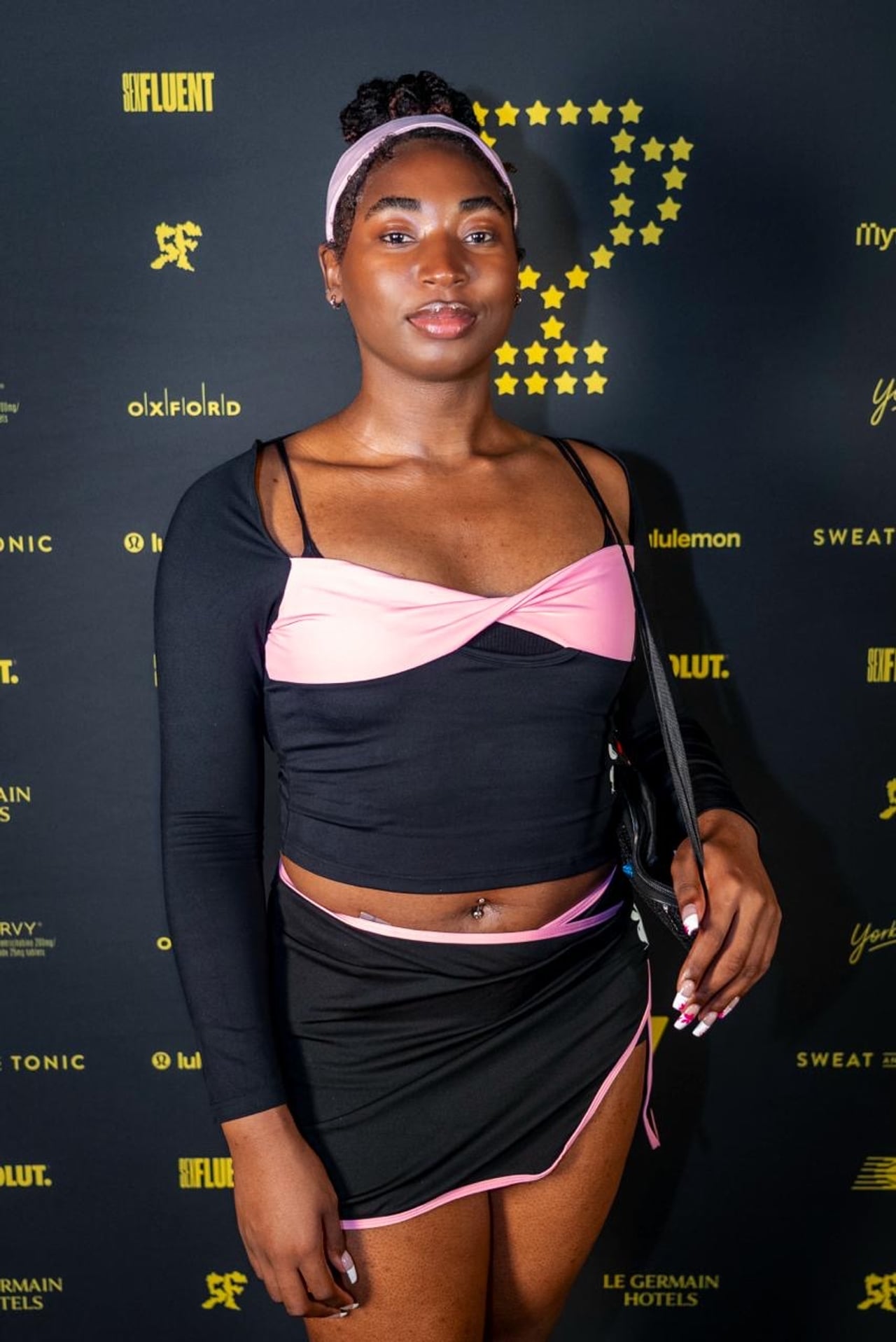 A performer in a pink and black athleisure set
