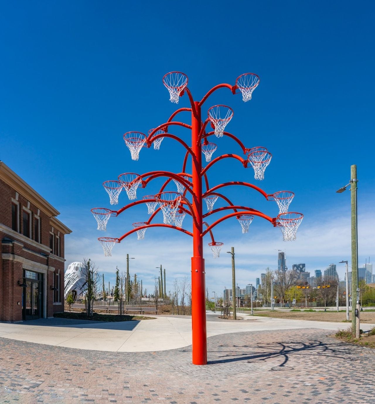 A sculpture shaped like a tree made from multiple basketball nets