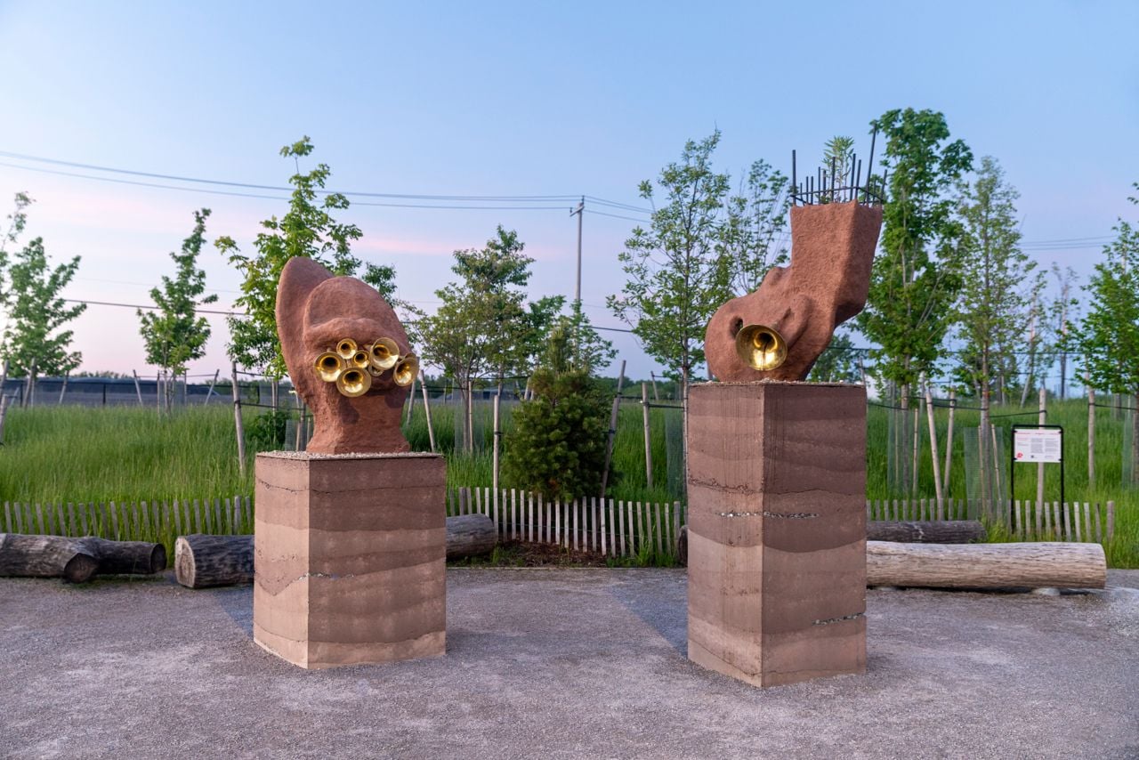 Two sculptures made of earth with trumpets inside