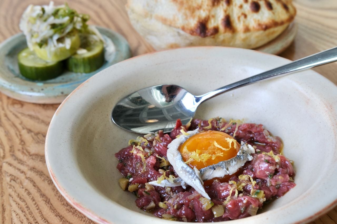 Lamb tartare topped with egg yolk and anchovies