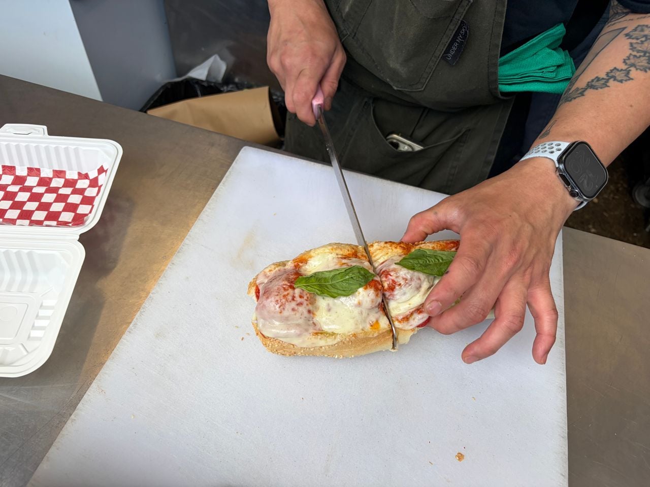 A chef prepares a meatball sub at Good Behaviour