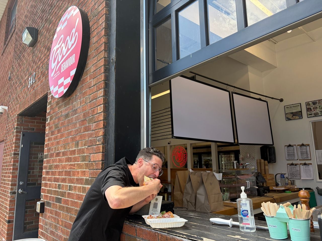 Adam Minster eats a meatball sub outside of Good Behaviour