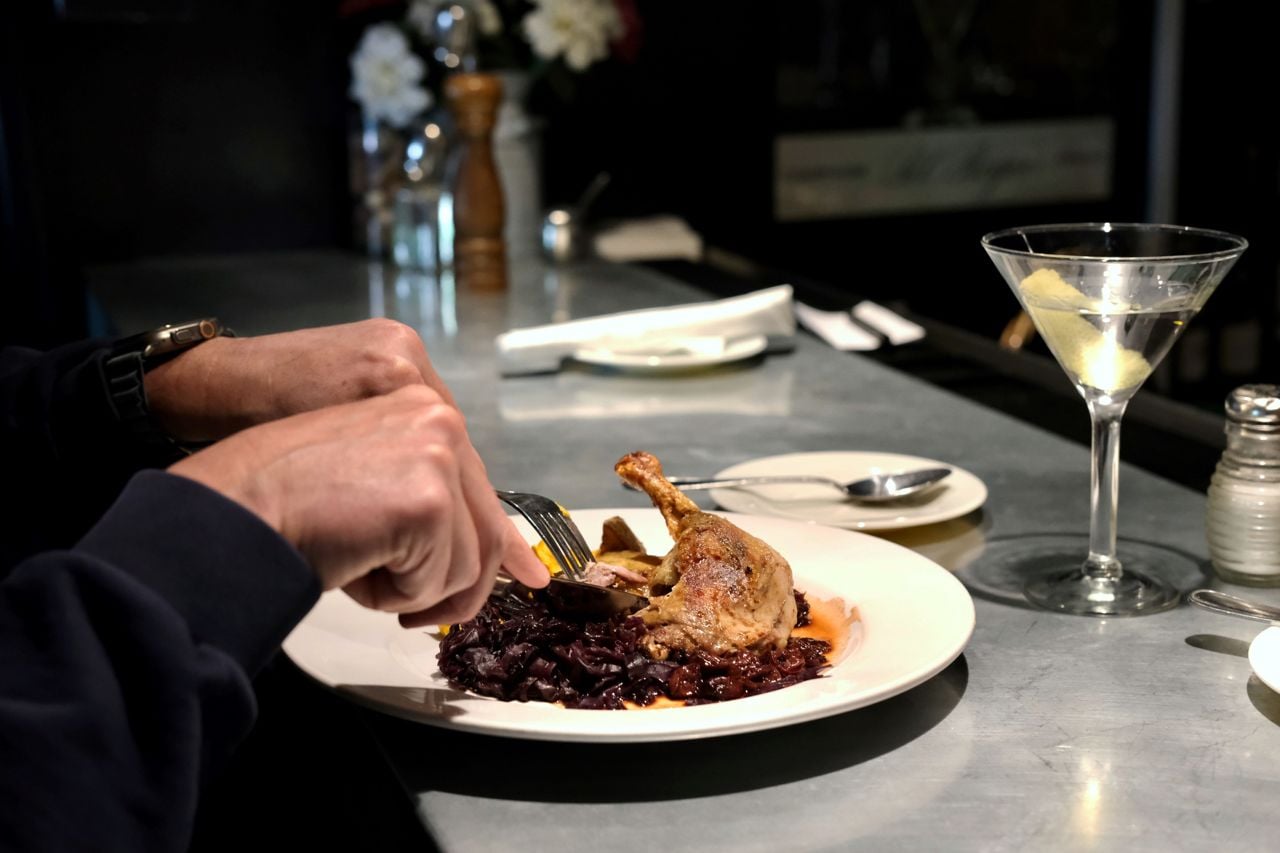 A person cuts into a duck leg