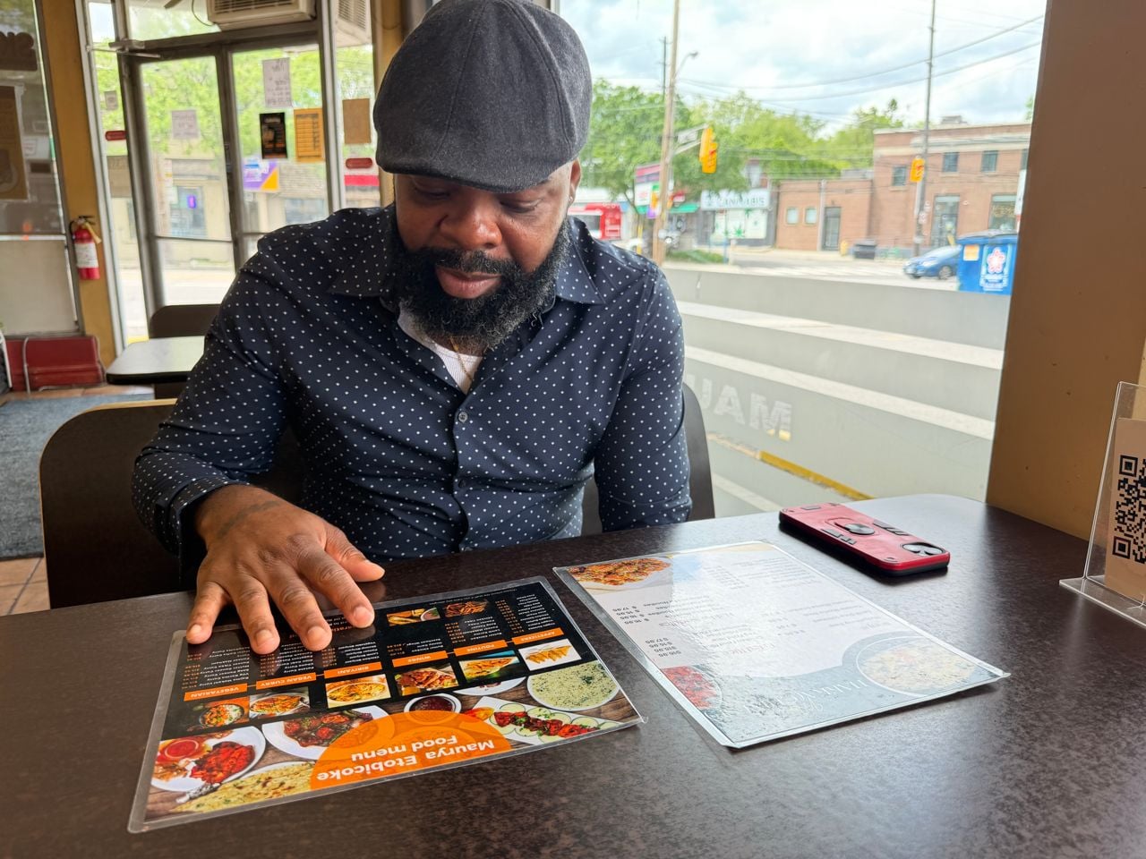 Chef James Obazee reads the menu at Maurya Roti in Etobicoke
