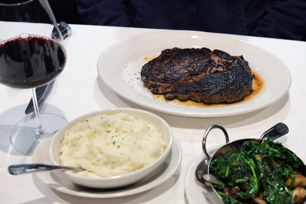 A steak, mashed potatoes, mushrooms and glass of red wine