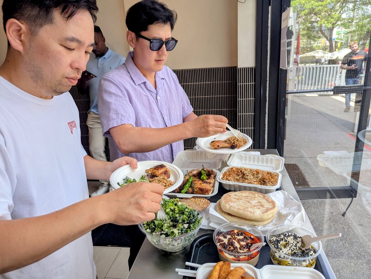 Chefs Jeff Kang and Ed Bang eat a spread of dishes at Mozy's Charcoal