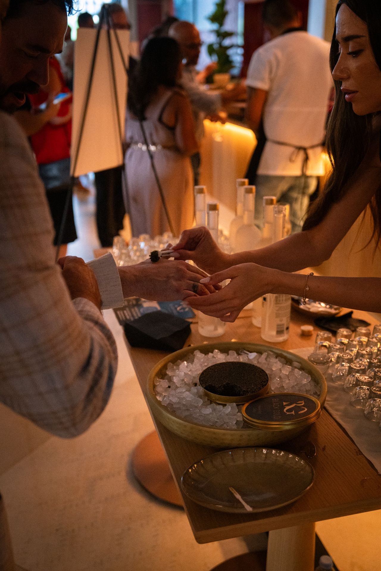 A server gives a caviar bump to a party guest at Queens Harbour