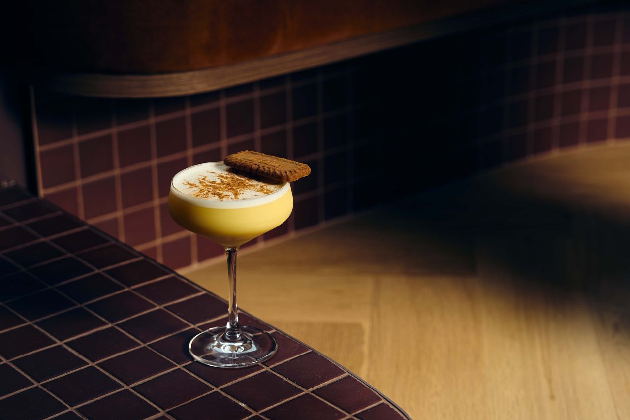 A cocktail with a cookie garnish