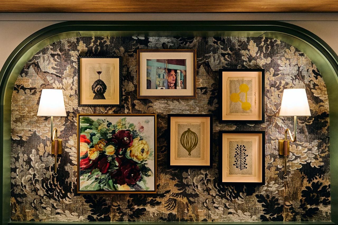 Framed art hangs on a wall covered in textured material