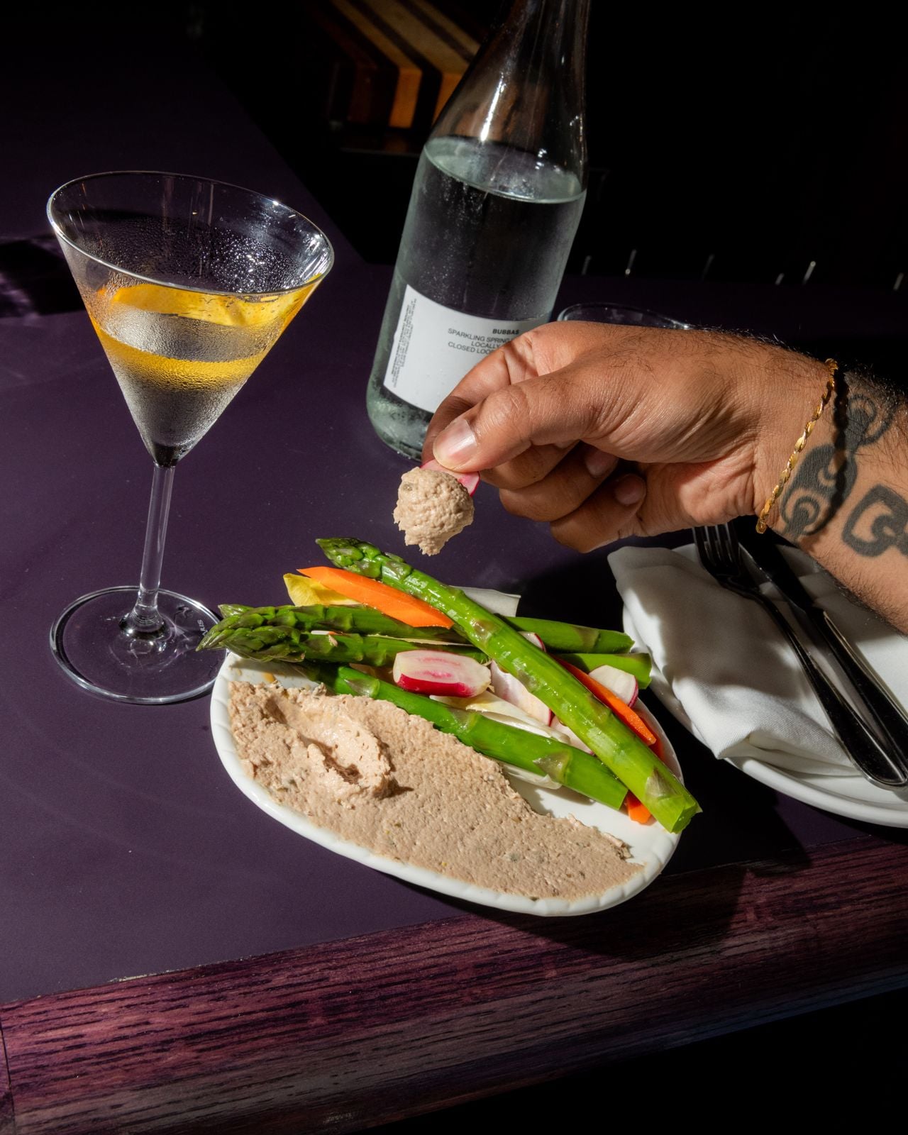 A plate of veggies and dip next to a martini