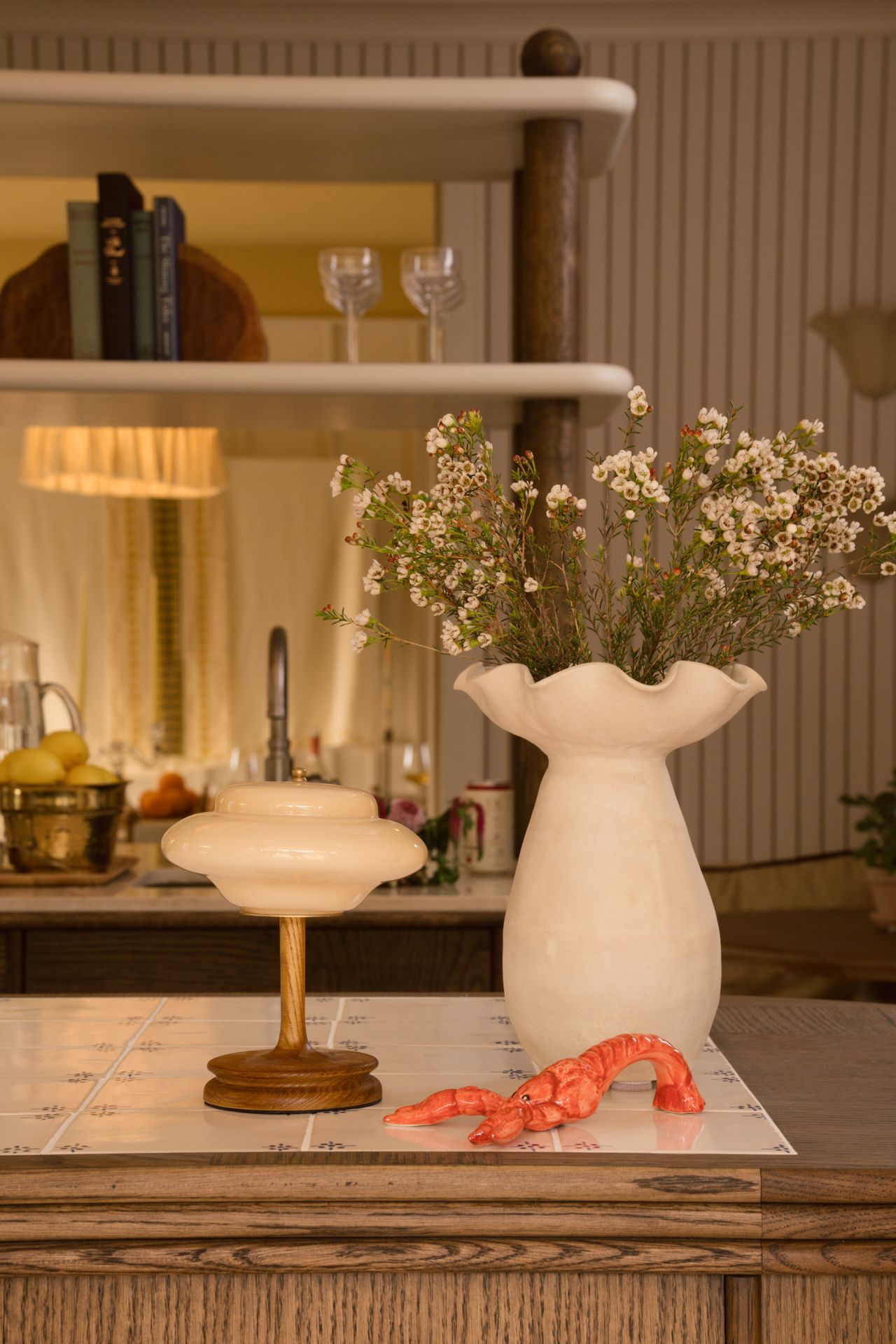 Ceramic lobster on a counter next to a white vase