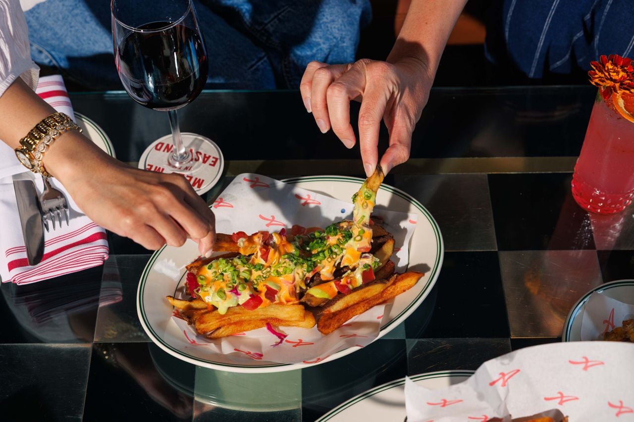 Hands reach for nacho fries