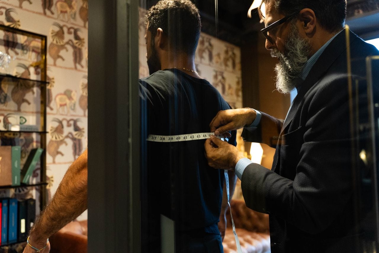 A tailor takes a man's measurements