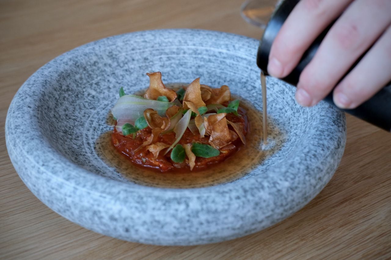 Albacore tuna swims in a punchy fermented tomato vinaigrette, with pickled celery ribbons, borage leaves and sunchoke chips