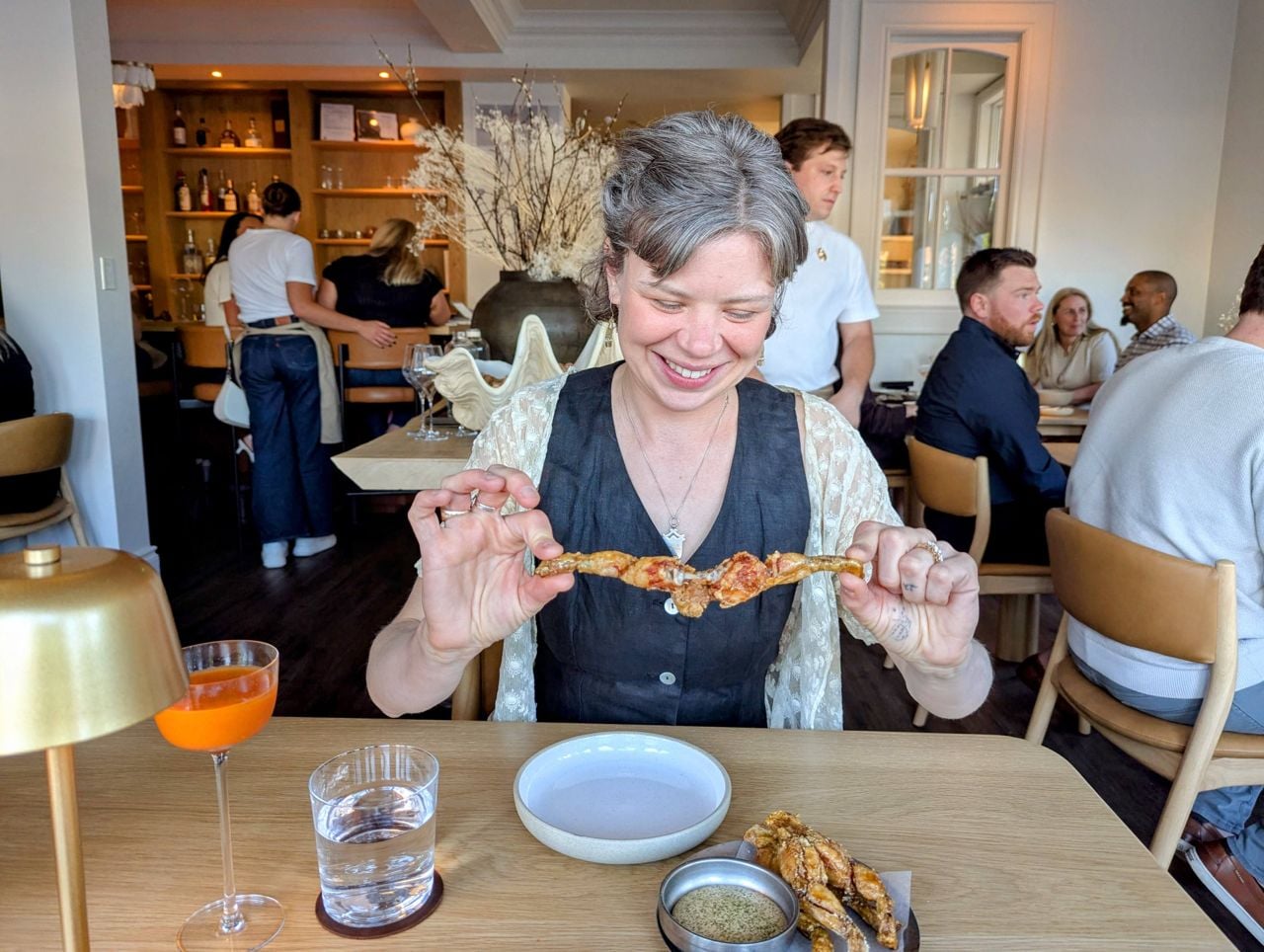 Maddie Calvert-Tarlo pulls apart frog legs at Lore Restaurant