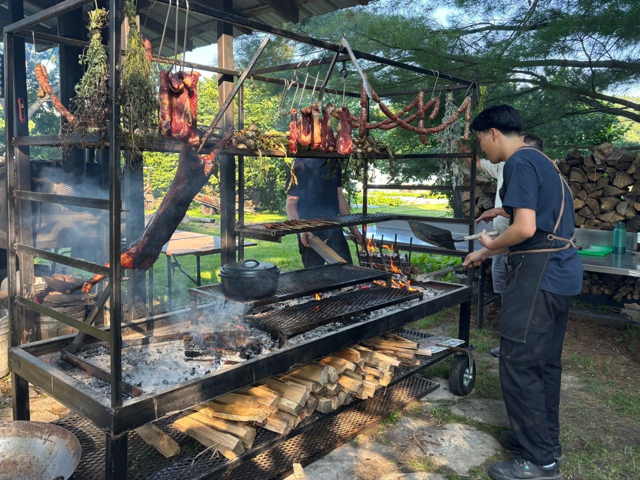 A chef works the grill at Paper Kite Farm