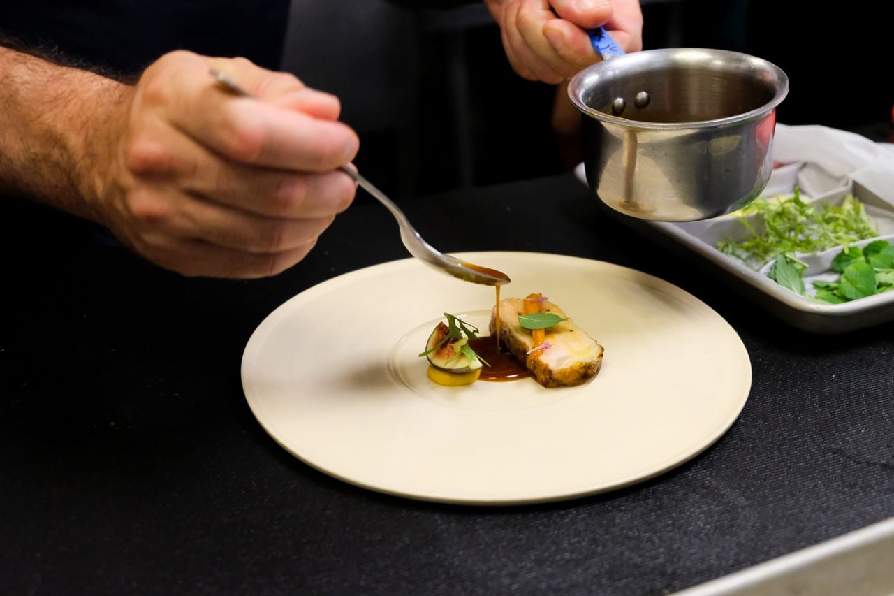 A chef plates a dish at Restaurant Pearl Morissette