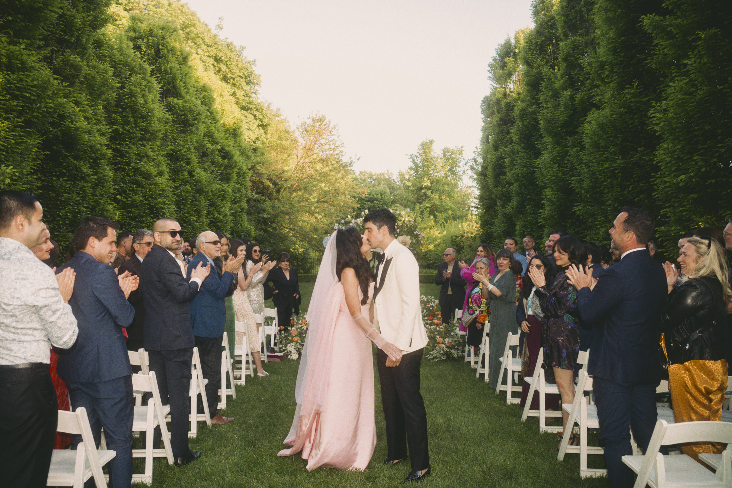 Roya and Mani kissing in the aisle during their wedding ceremony