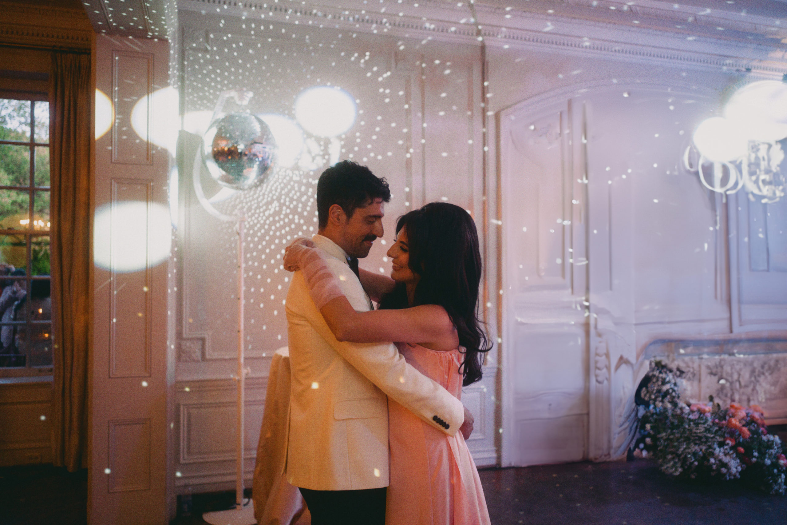 Roya and Mani dancing underneath a disco ball